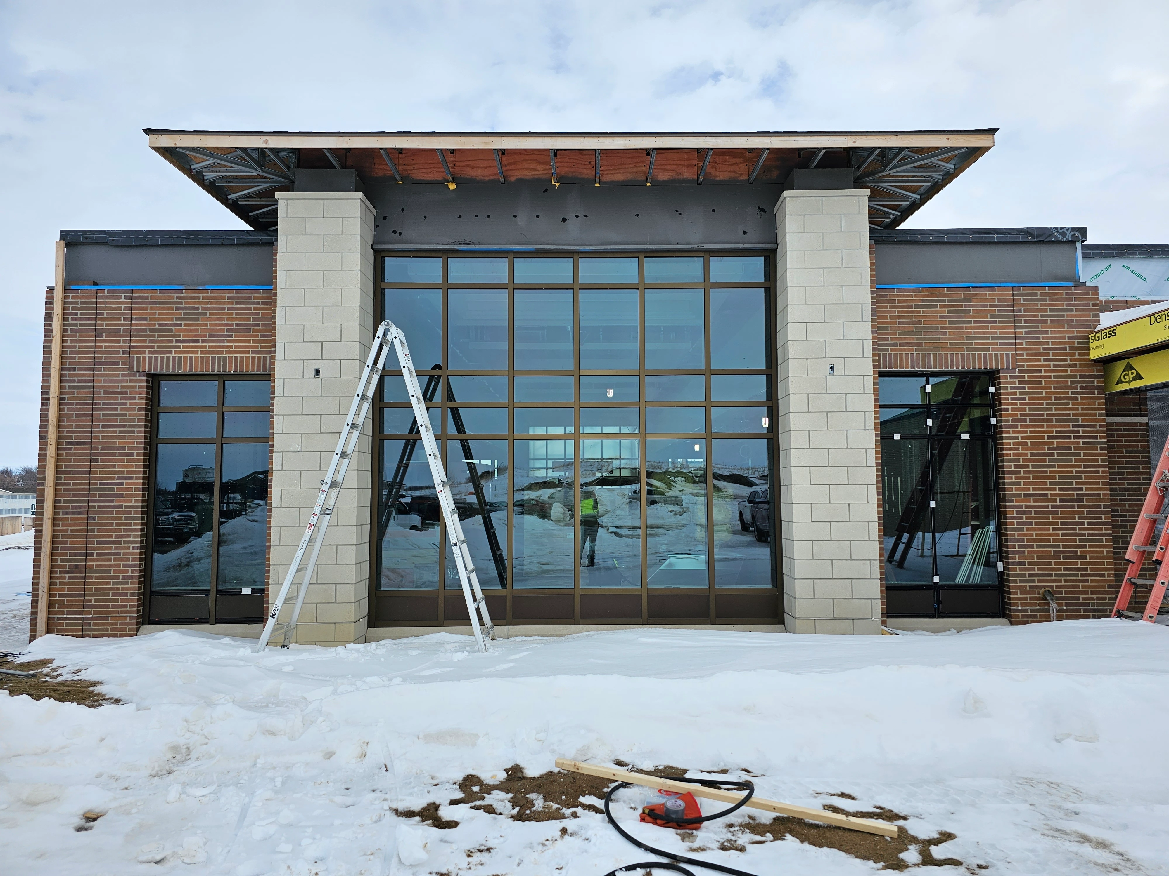 An unfinished building with a sizable window, indicating ongoing construction activities.